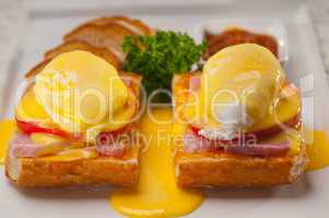 eggs benedict on bread with tomato and ham