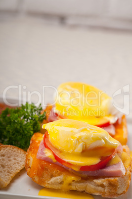 eggs benedict on bread with tomato and ham