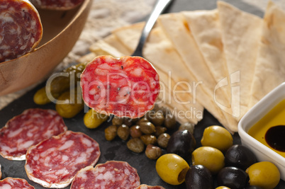 cold cut platter with pita bread and pickles