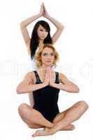 Zwei Frauen meditieren im sitzen und stehen