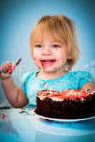 Little baby girl eating cake
