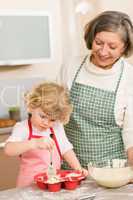 Woman and little girl baking cupcakes together