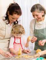 Little girl with mother cutting out cookies