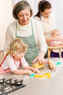 Little girl cutting dough for cookies
