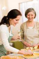 Two happy women enjoy baking apple pie