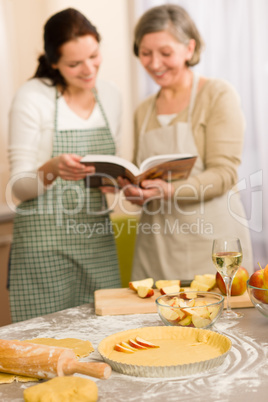 Apple pie recipe two women looking cookbook