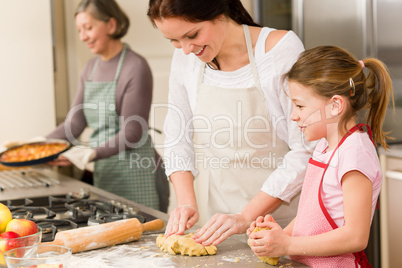 3 generations of women baking apple pies