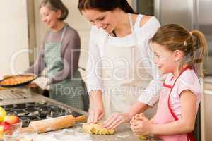 3 generations of women baking apple pies