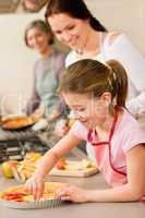 Young girl prepare apple pie with mother