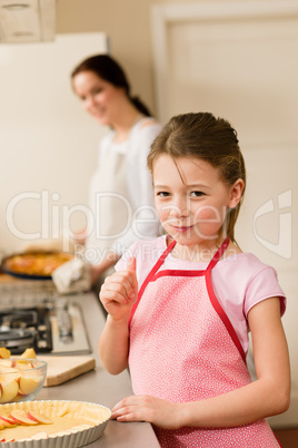 Young girl baking apple pie thumb up