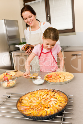 Mother and daughter make apple pie recipe