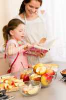 Mother and daughter look baking cookbook