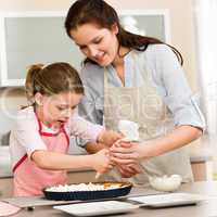 Decorating cake mother and daughter