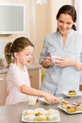Little girl pointing cupcake to her mother