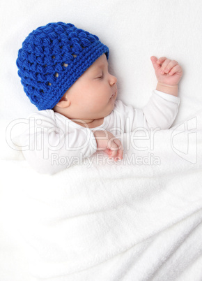 Beautiful baby sleeping on bed under a white blanket