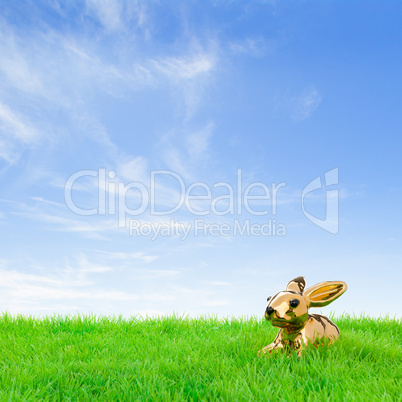 Golden easter bunny in a bright field
