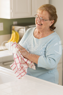 Senior Adult Woman Drying Bowl At Sink in Kitchen