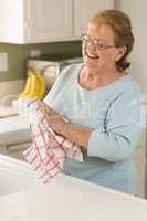 Senior Adult Woman Drying Bowl At Sink in Kitchen