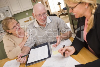 Senior Adult Couple Going Over Papers in Their Home with Agent