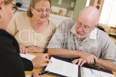 Senior Adult Couple Going Over Papers in Their Home with Agent