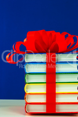 Stack of colorful books tied up with ribbon