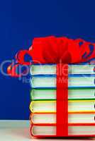 Stack of colorful books tied up with ribbon