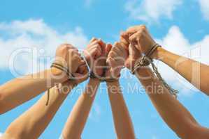 Three pairs of human hands tied up together
