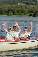 Cheerful young men sitting in motorboat