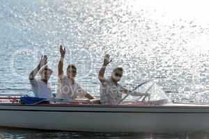 Waving young men silhouette driving powerboat