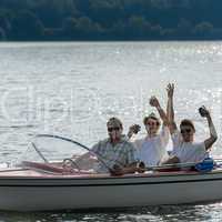 Cheerful young men drink beer speed boat