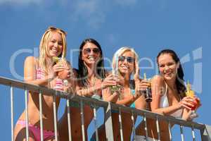 Beautiful women in bikinis smiling with drinks