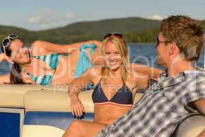 Sunbathing friends lying on summer yacht