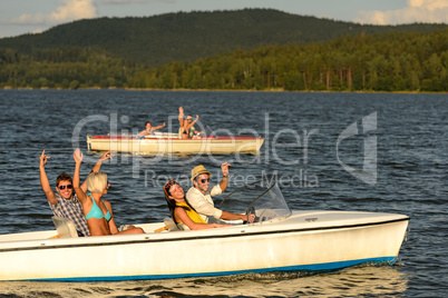 Group of friends racing with motorboats
