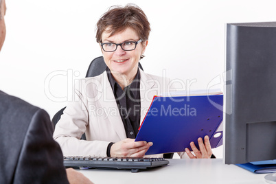 Business woman with folder speaks to man in a suit