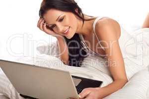 beautiful woman using a laptop in bed