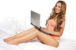 woman relaxing on her bed with a laptop