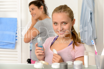 Two young sisters getting ready in bathroom