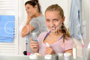 Two young sisters getting ready in bathroom
