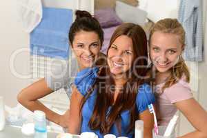 Three young girl friends posing in bathroom