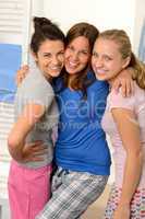 Three teenage girls laughing in pajamas