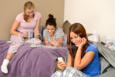 Smiling teenager girl sending text message