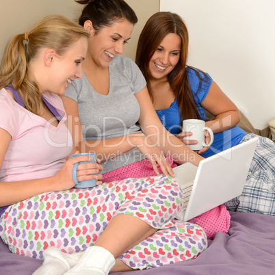 Three cheerful girls surfing on the net