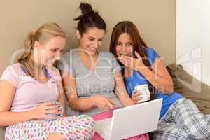 Three young girls watching movie on laptop