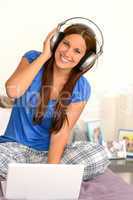Cheerful teenager girl listening music headphones