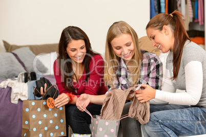 Three cheerful girls with clothes from sale