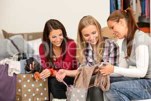 Three cheerful girls with clothes from sale