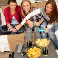 Laughing teenage girls playing with video game
