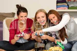 Laughing young girls playing with video games
