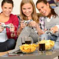 Smiling teenage girls playing with video games