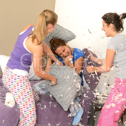 Teenager girls pillow fighting in bedroom